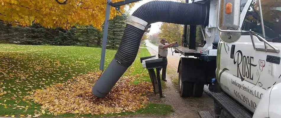 A Rose Landscape Services work truck removing leaves from a Ada, MI property.